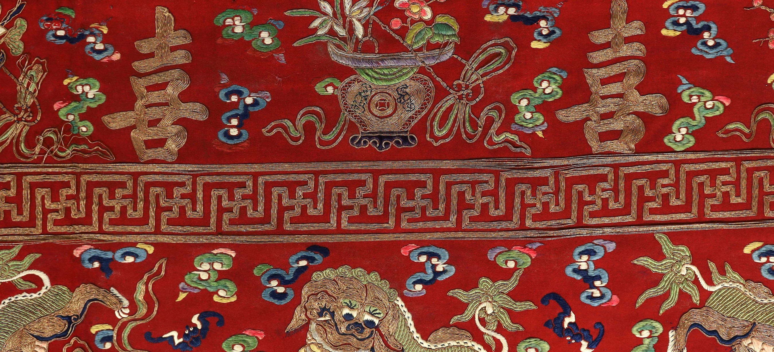 A Chinese embroidered silk ‘dragon, phoenix and lion’ panel or table frontal, late Qing dynasty, 117cm x 337cm